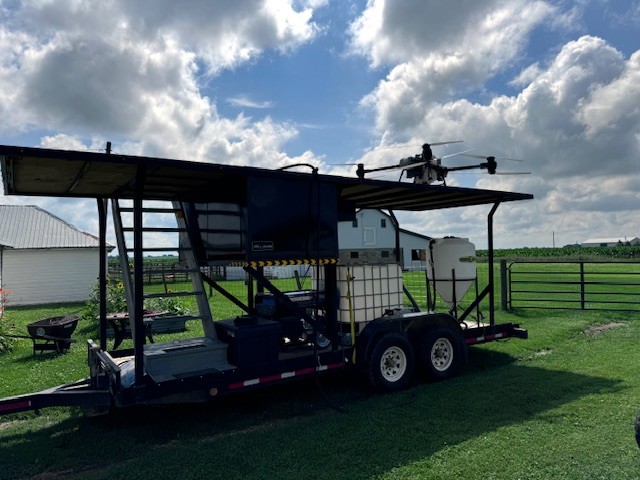 Mobile trailer with elevated drone landing deck and mix station